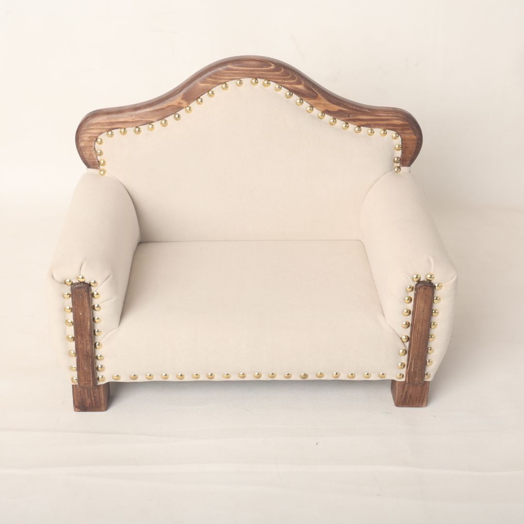 A sleek and elegant wooden sofa baby prop, designed for newborn and sitter photoshoots, offering a stylish and comfortable seating option for capturing timeless baby portraits.